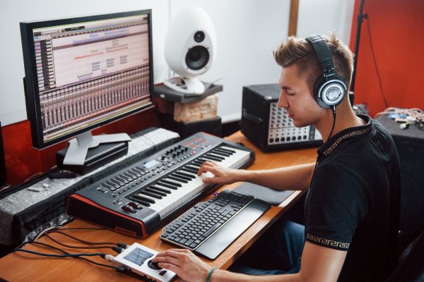 Sound engineer in headphones working and mixing music indoors in the studio